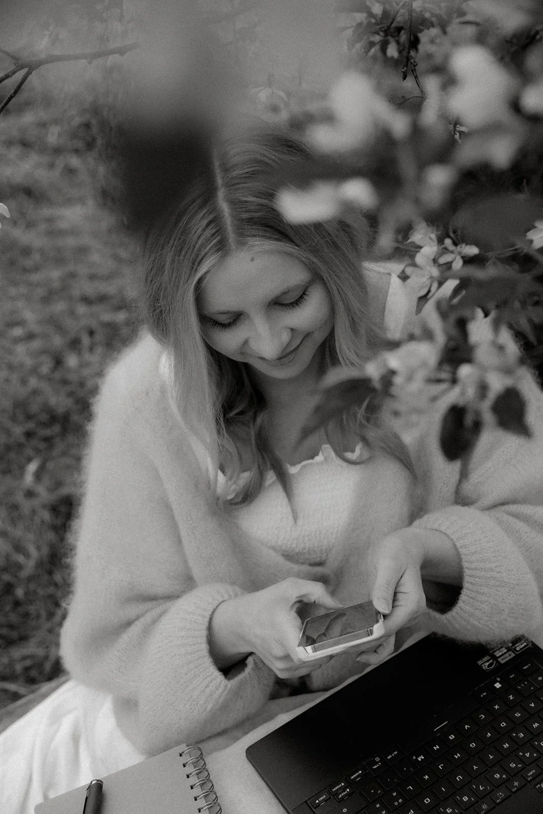 Brändikuvaus luontomaisemassa. Yrittäjä selaa puhelintaan.