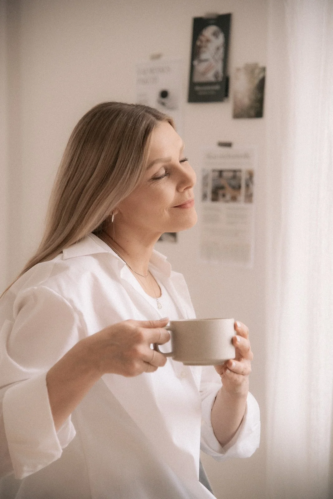 Naisyrittäjä silmät kiinni kahvikuppi käsissään. Kuvannut henkilökuvaaja Heidi Väisänen.