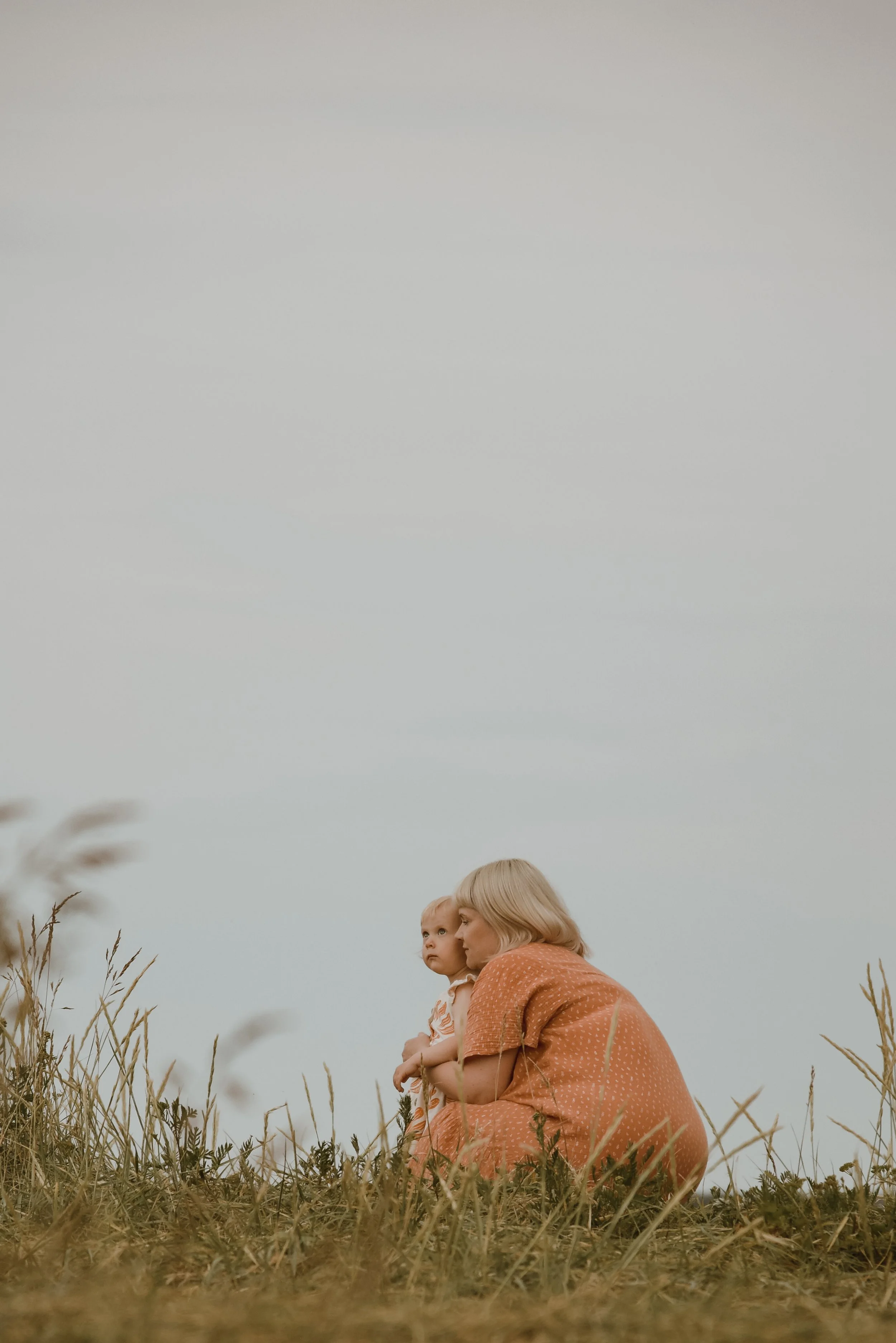 Perhekuvaus luontomaisemassa, äiti halaa lastaan. Kuvannut valokuvaaja Heidi Väisänen.
