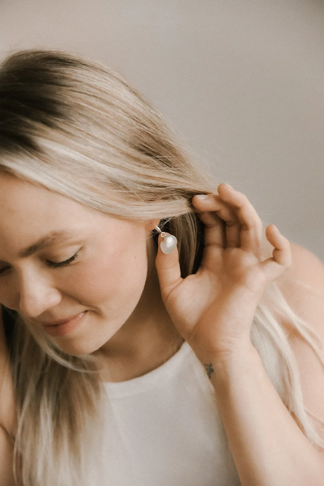 Tuotekuvaus, naisyrittäjä Jenni Boughanmin korvissa hänen suunnittelemansa korvakorut.