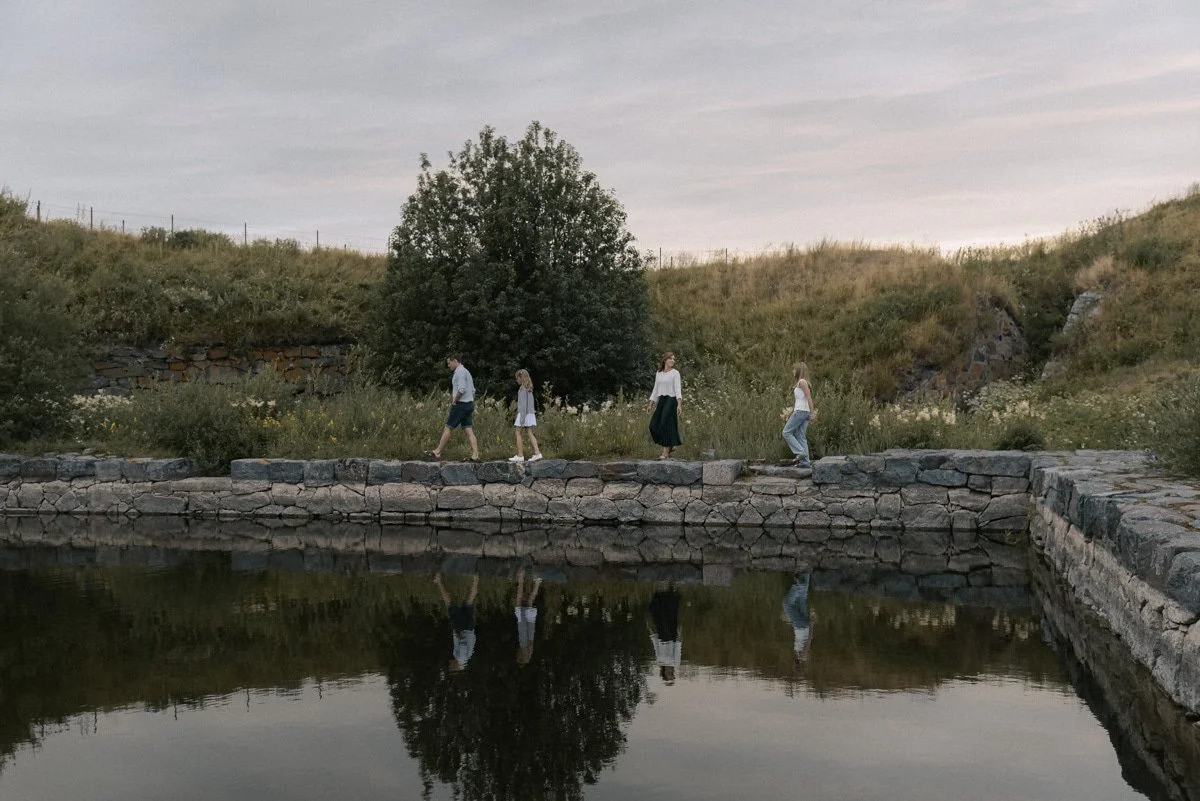 Perhekuvaus miljöössä, nelihenkinen perhe kävelee kauniissa maisemassa. Kuvannut valokuvaaja Heidi Väisänen.