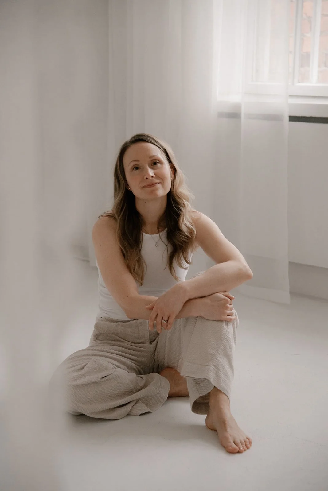 Vaumiin yrittäjä istuu harmonisen kuvausstudion lattialla. Kuvannut yrityskuvaaja Heidi Väisänen.