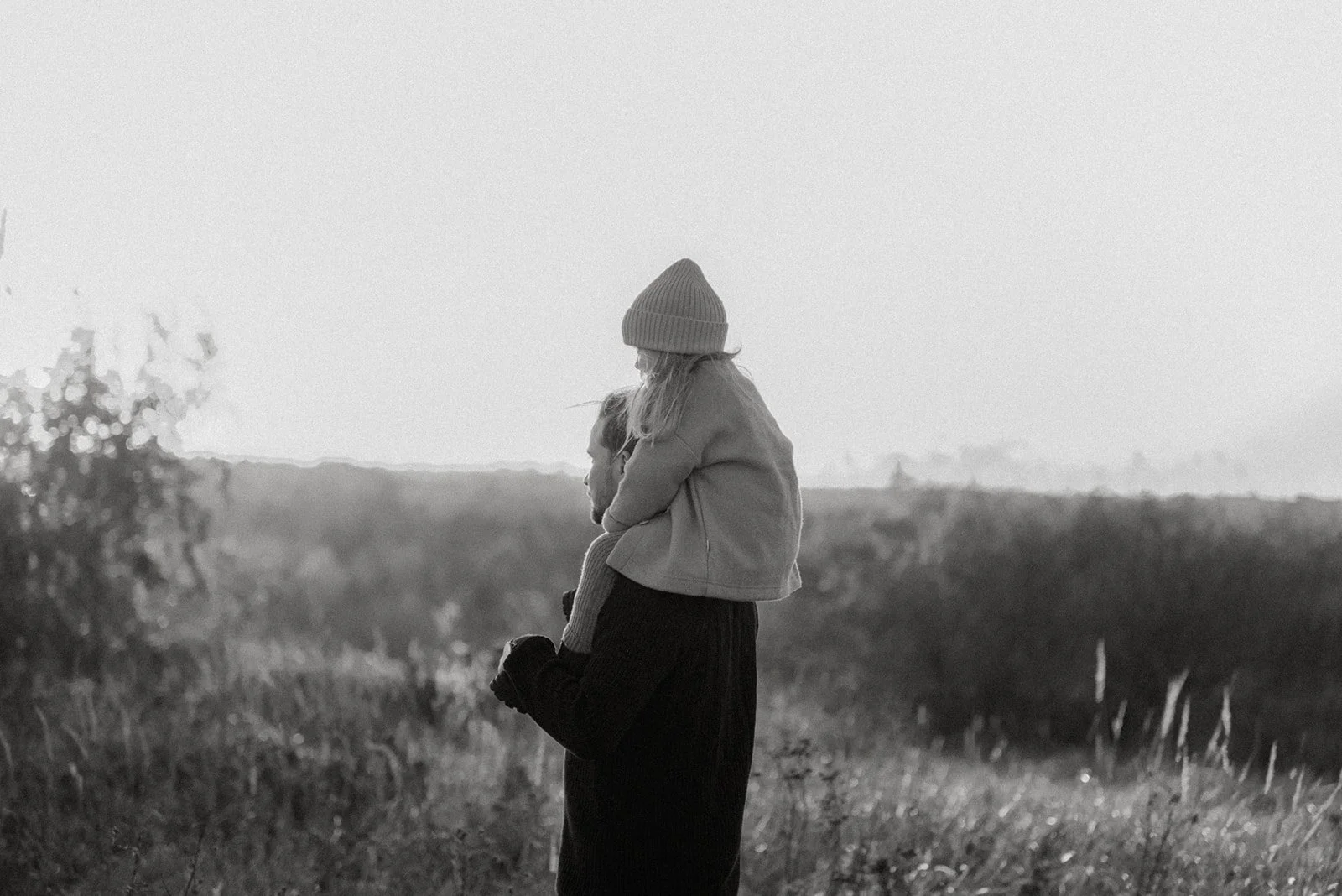 Perhekuvaus luontomiljöössä, lapsi isän olkapäillä. Kuvannut valokuvaaja Heidi Väisänen.
