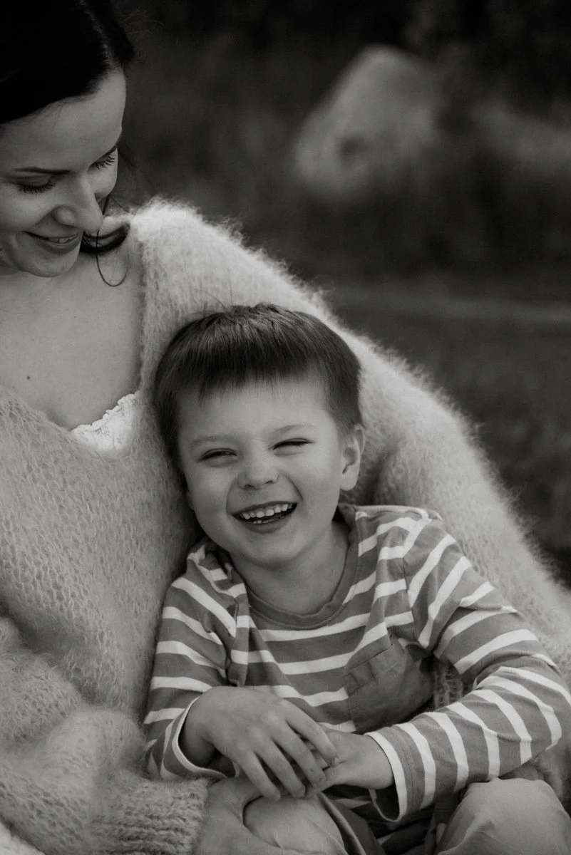 Mustavalkokuva lapsesta äidin sylissä.