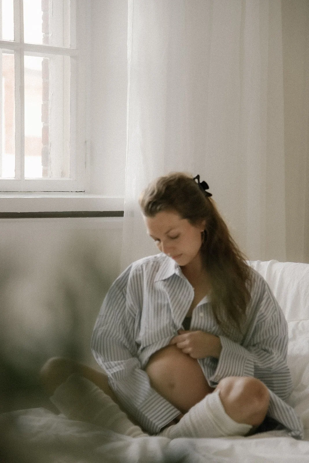 Valoisassa studiossa odottava äiti yllään sininen kauluspaita. Odotusajankuvaus Heidi Väisäsen studiolla Keravan Saviossa.