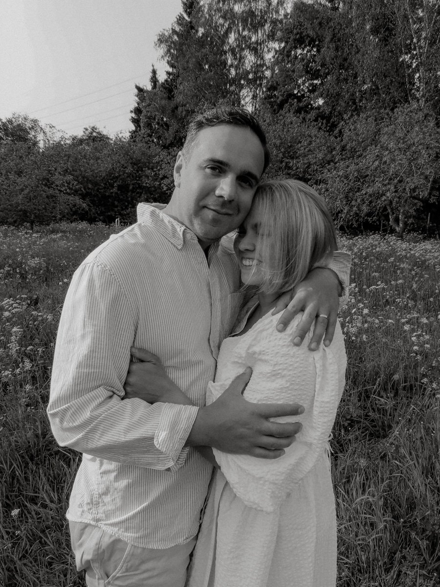 Pariskunta halaa luontomaisemassa.