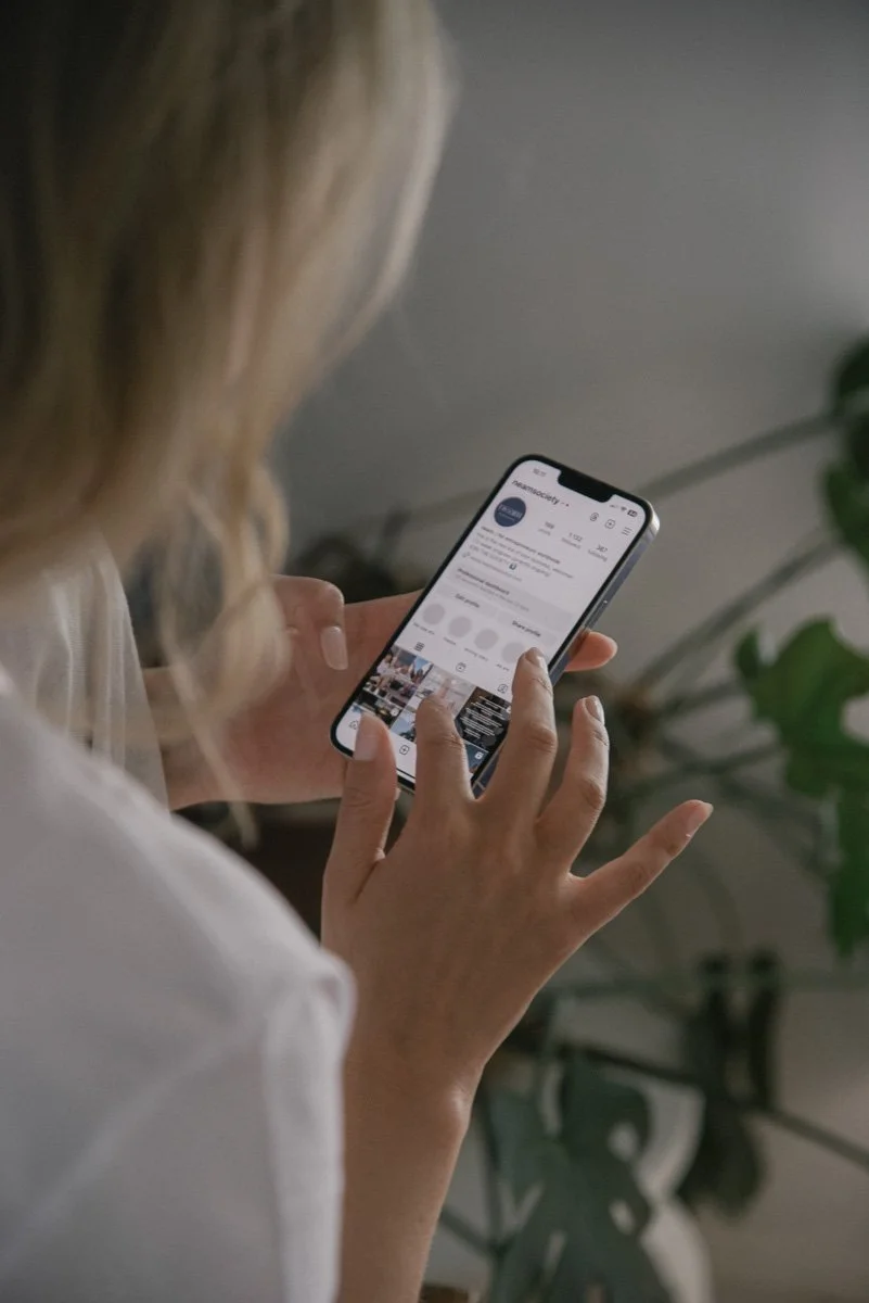 Neam Societyn yrittäjä näpyttelee kännykkää. Kuvannut yrityskuvaaja Heidi Väisänen.