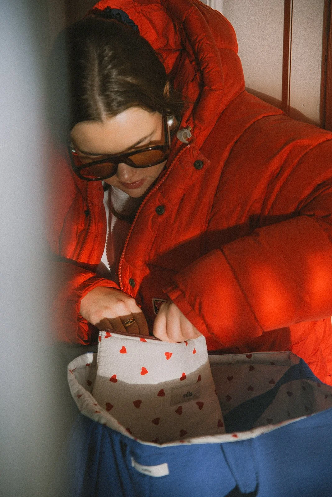 Edlan yrittäjä kaivaa brändin pussukoita punaisessa takissa.