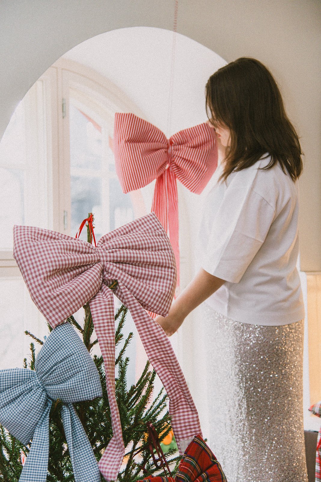 Edlan brändikuva, yrittäjä asettelee rusetteja joulukuuseen.