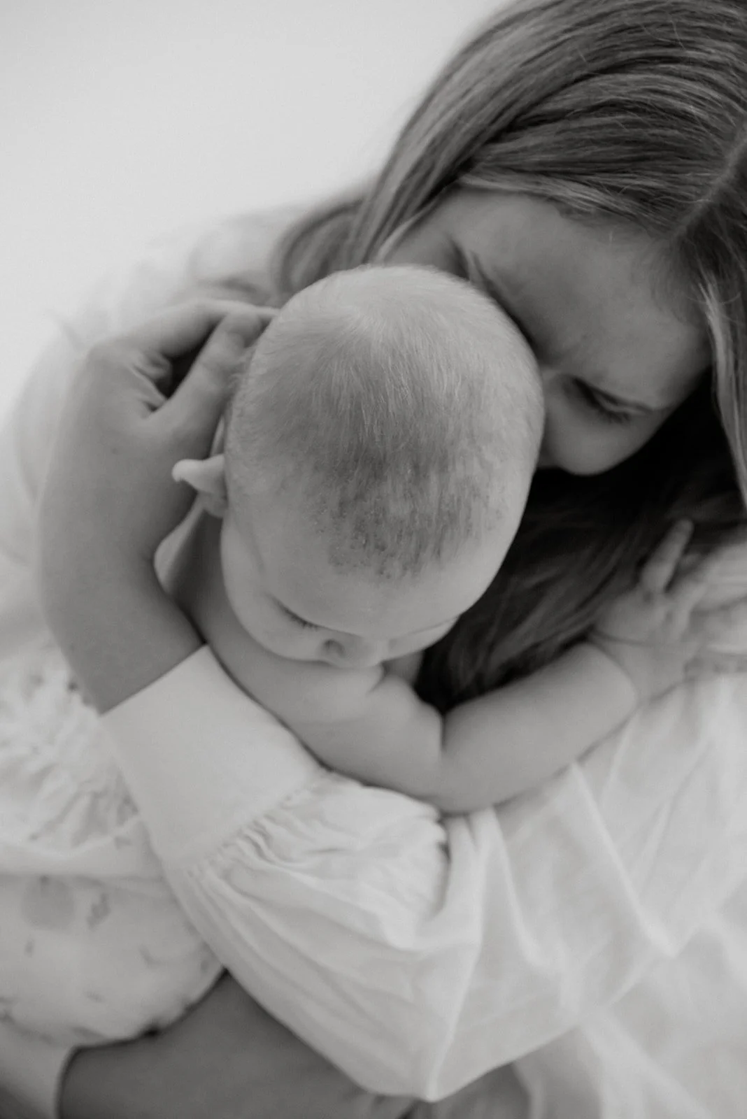 Äiti ja lapsi kuvattavana valoa tulvivassa studiossa.