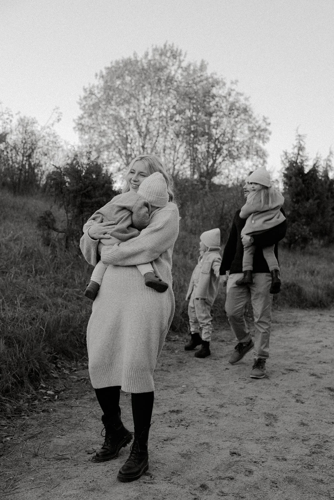 Perhevalokuvaus Helsinki, äiti, isä ja kolme lasta kävelemässä luonnossa.