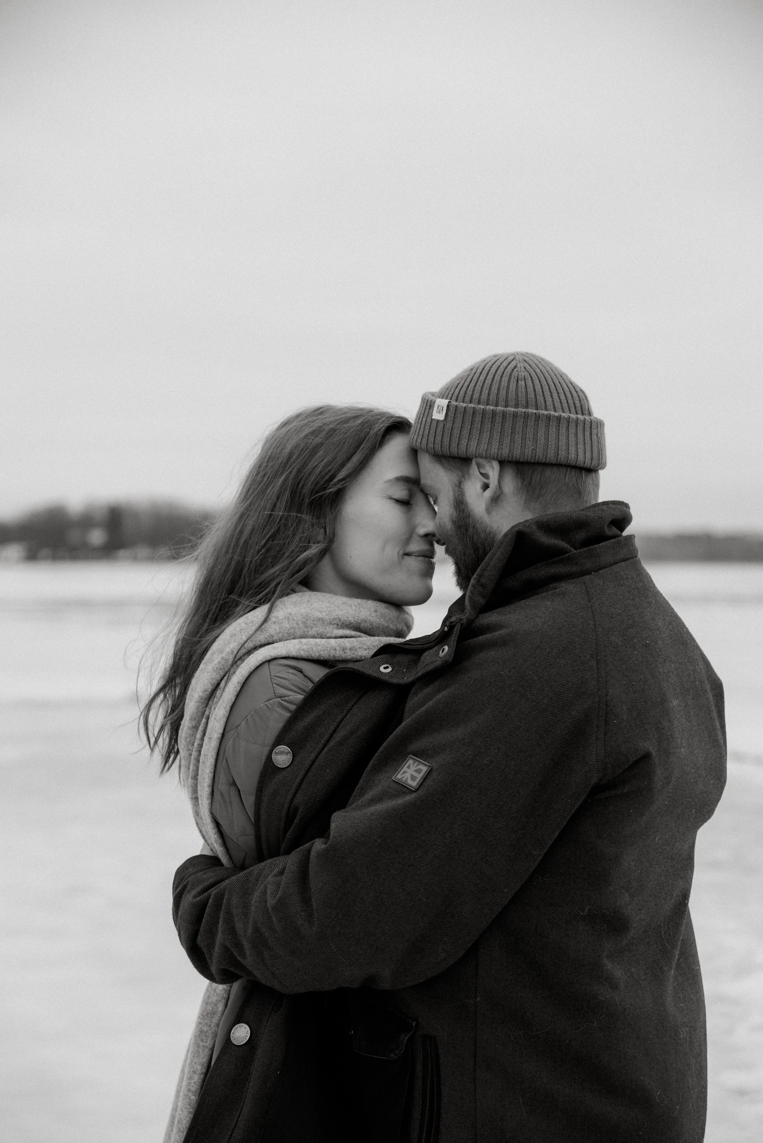 Nainen miehen syleilyssä tunnelmallisessa kuvassa. Kuvannut Heidi Väisänen.