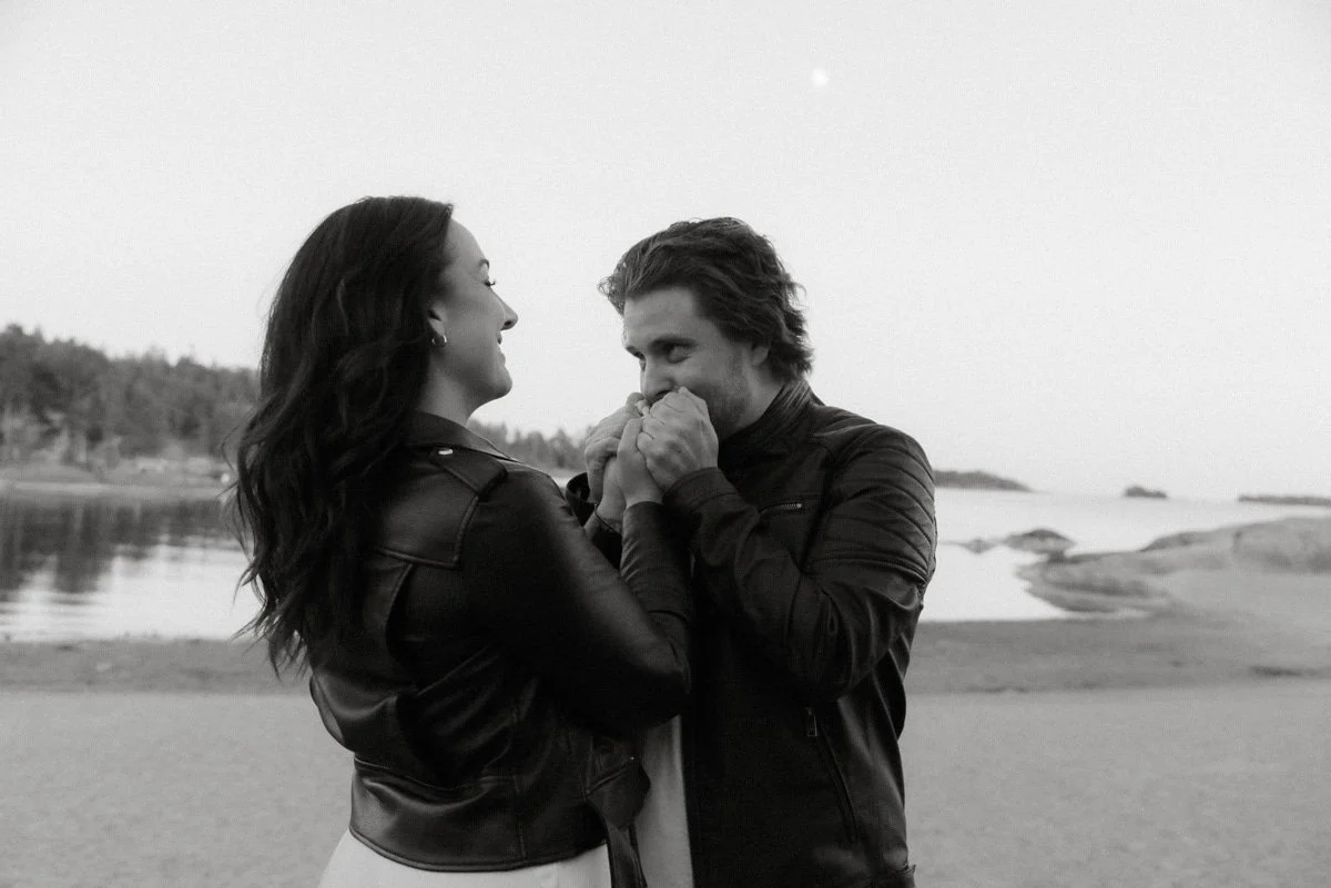 Pariskunta rannalla veden edustalla. Kihlakuvaus Lauttasaari.