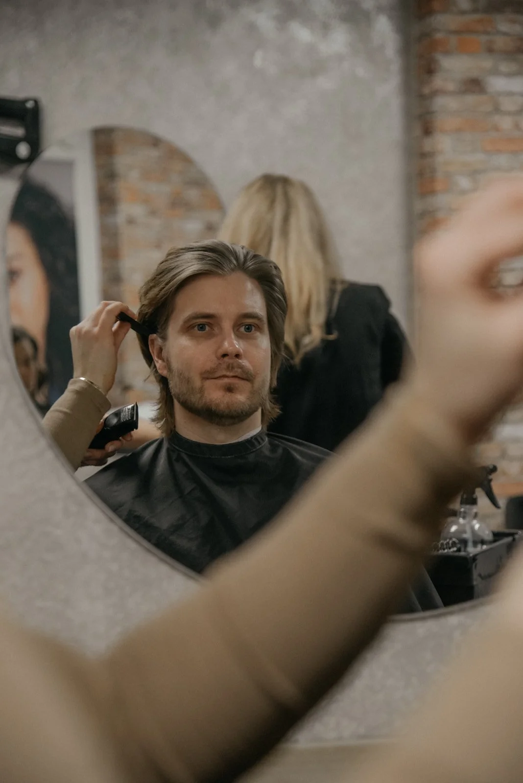 Hykken brändikuvaus. Kampaajan asiakas peilin kautta kuvattuna.