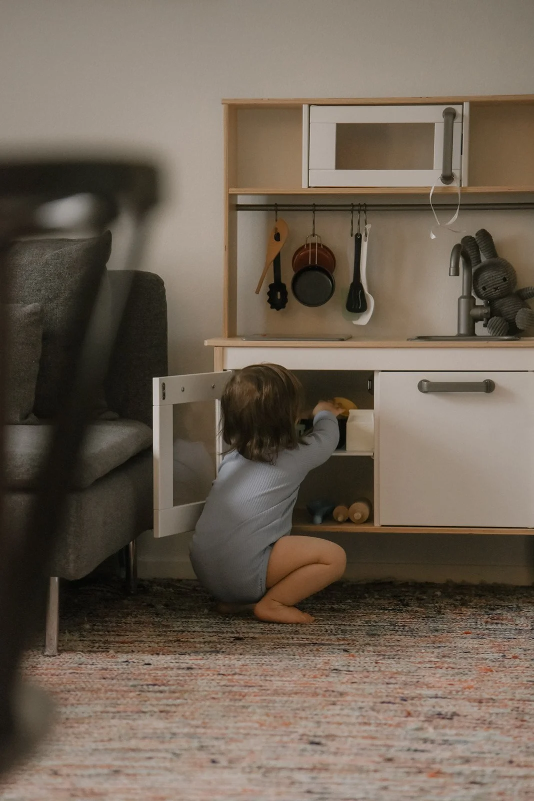 Pieni taapero leikkii rennosti kotonaan. Lapsikuvaus Vantaa.