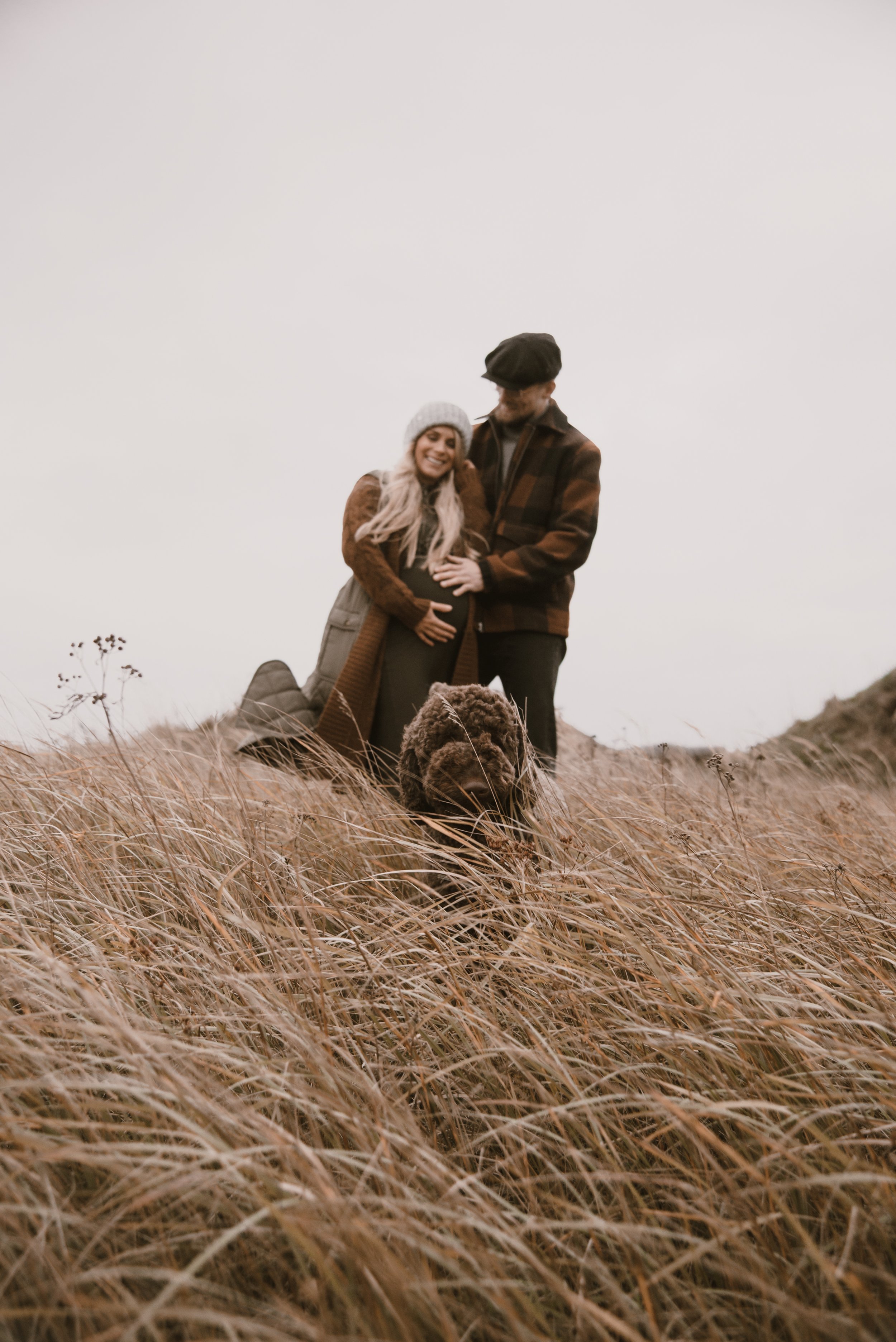 Perhe heinikossa koiransa kanssa. Odotusajan kuvaus Espoo.