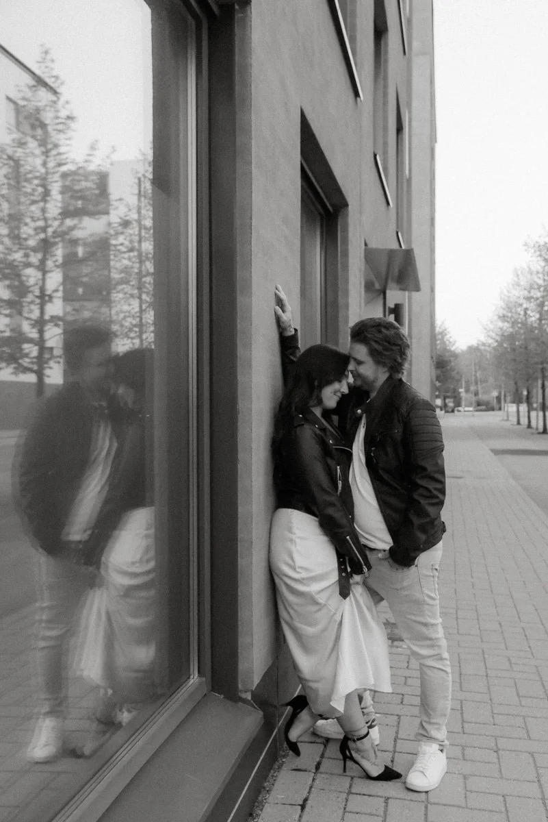 Mustavalkoinen kuva, jossa pariskunta nojaa toisiinsa kadulla. Pariskuntakuvaus Vantaa.