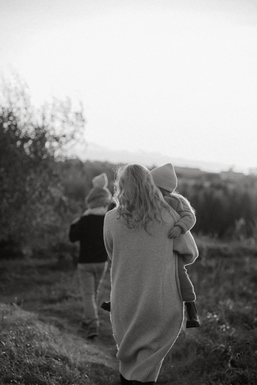 Perhe kävelee luontomaisemassa.