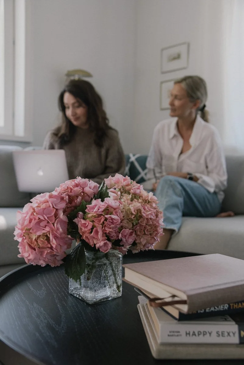 Neam Societyn brändikuvaus, naisyrittäjät tekevät töitä olohuoneen sohvalla.