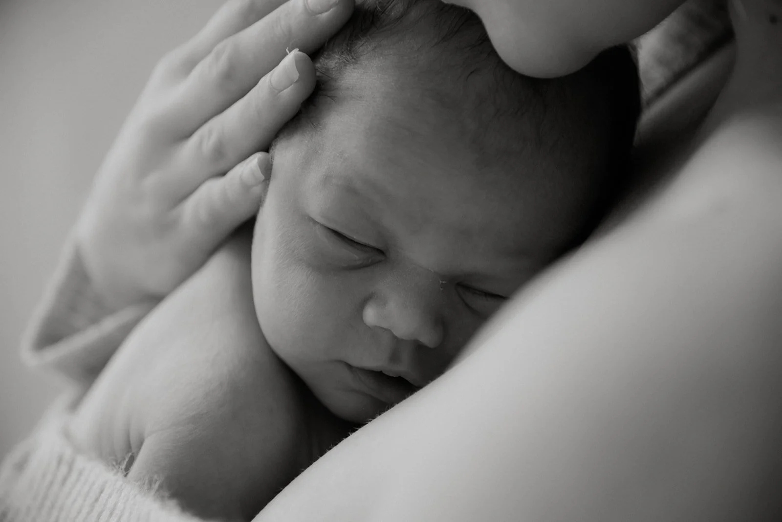 Lähikuvassa pieni vauva äidin ihoa vasten. Kuvannut Heidi Väisänen.