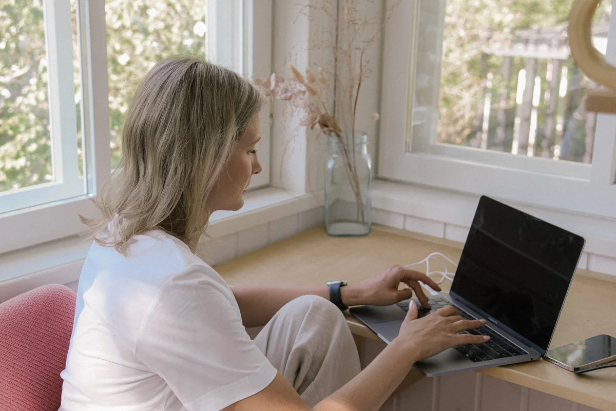 Neam Societyn yrittäjä näpyttelee tietokonetta. Kuvannut yrityskuvaaja Heidi Väisänen.