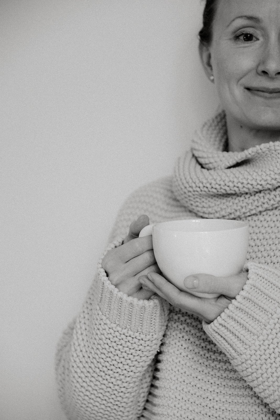 Vaumiin yrityskuvaus. Hymyilevä yrittäjä pitelee kahvikuppia käsissään.