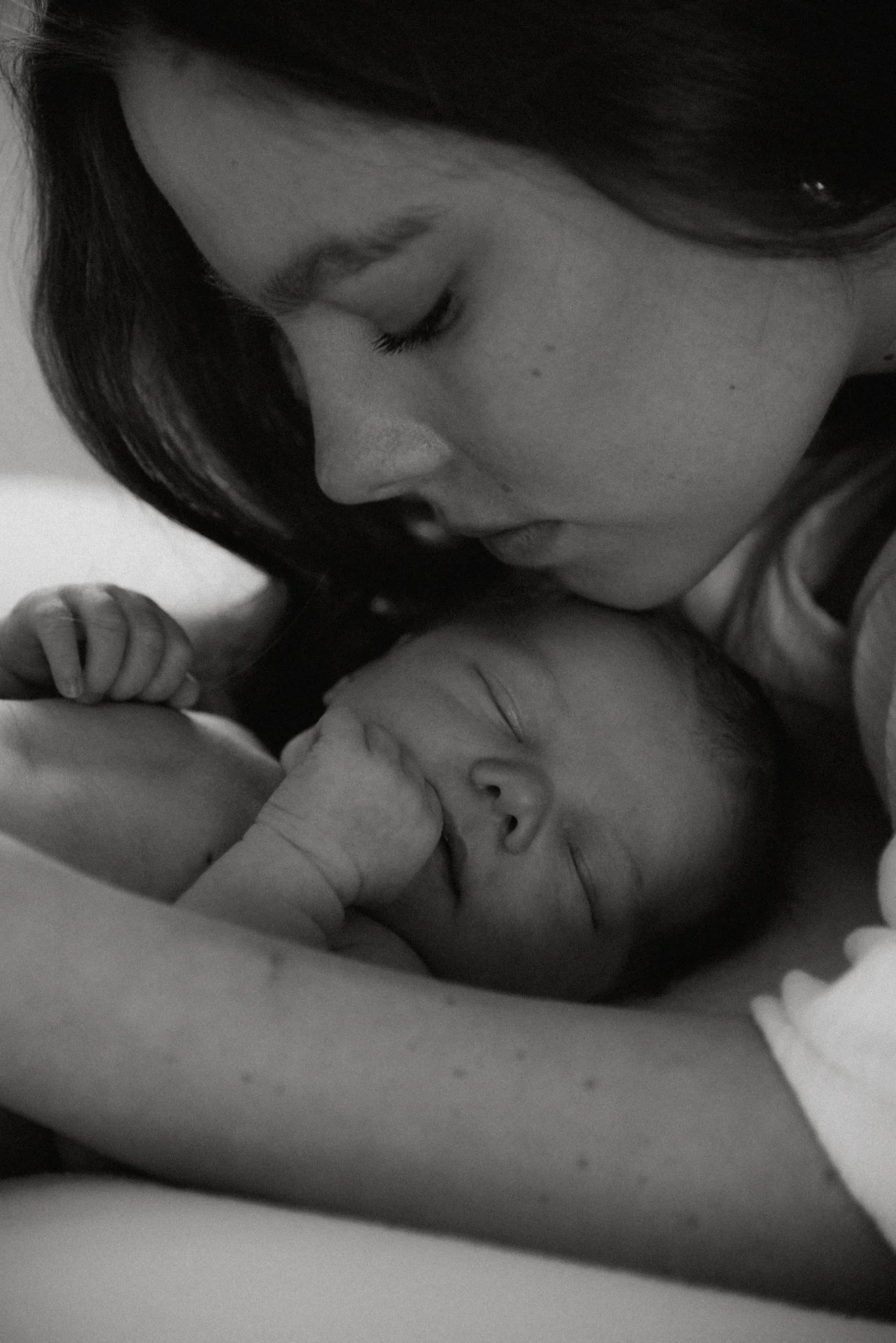 Mustavalkoinen lähikuva äidistä ja vauvasta. Kuvan on ottanut vauvakuvaaja Heidi Väisänen.