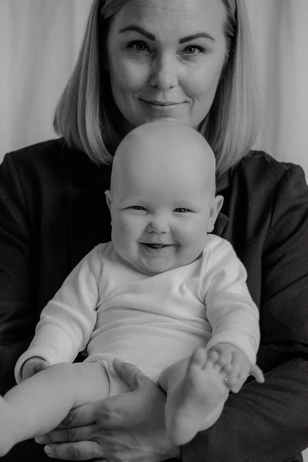 Iloinen vauva äidin sylissä. Äiti- ja lapsikuvaus.