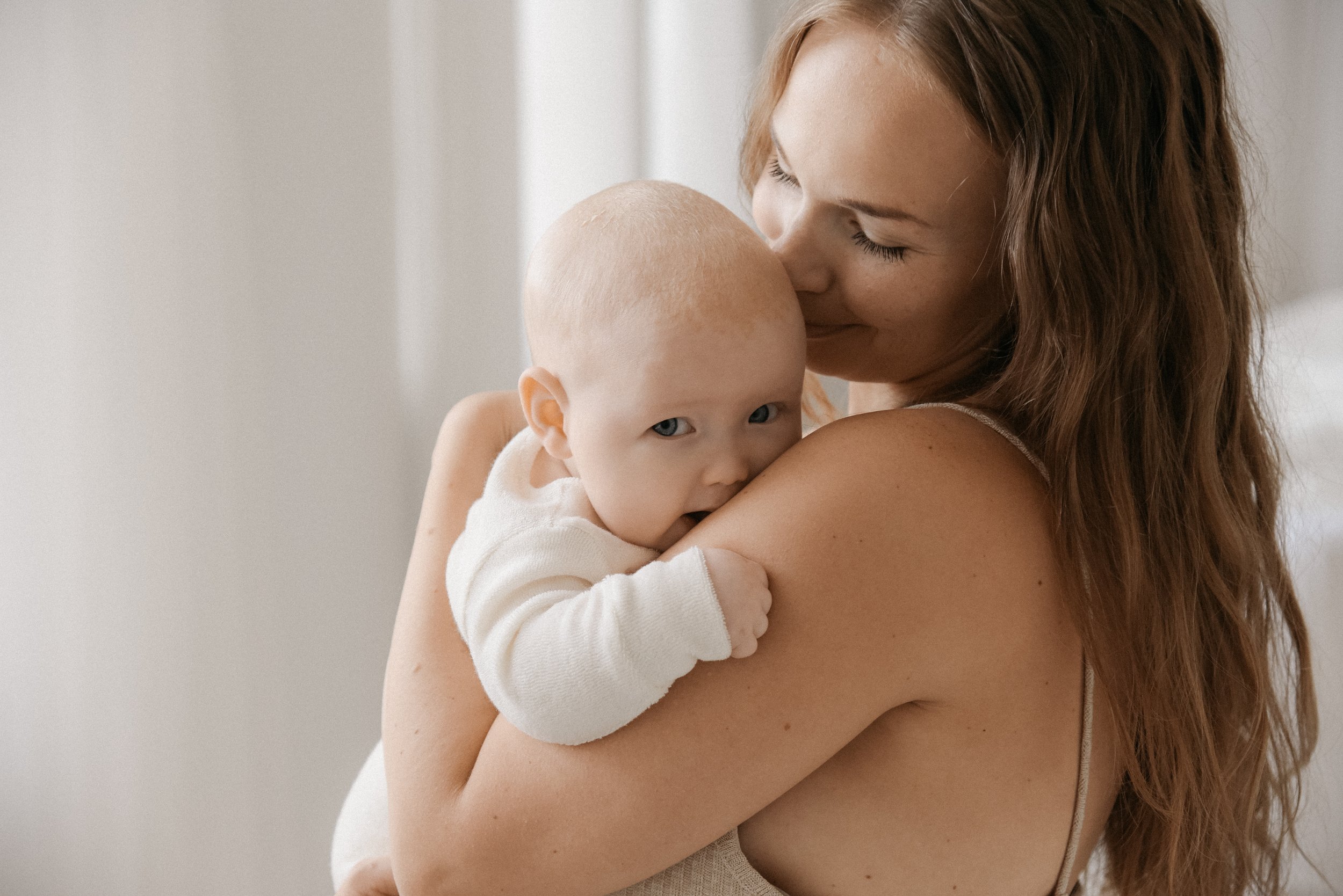 Äidin ja lapsen yhteiskuva. Äidin lämmin syli vauvalle.