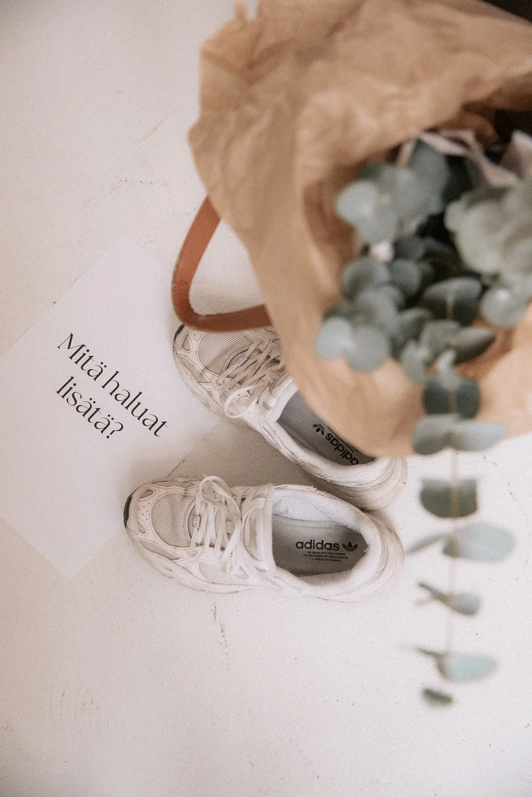 Kukkakimppu, tennarit ja paperi, jossa lukee "Mitä haluat lisätä?".