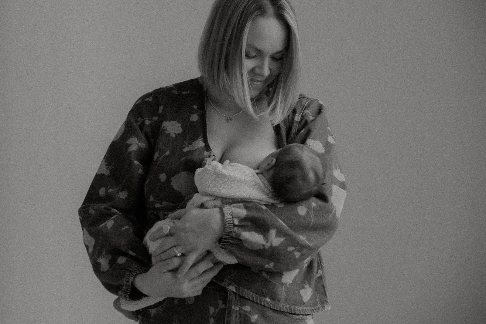 Äiti imettää lastaan mustavalkoisessa kuvassa. Vauvakuvaus valokuvaaja Heidi Väisäsen studiolla Keravan Saviossa.