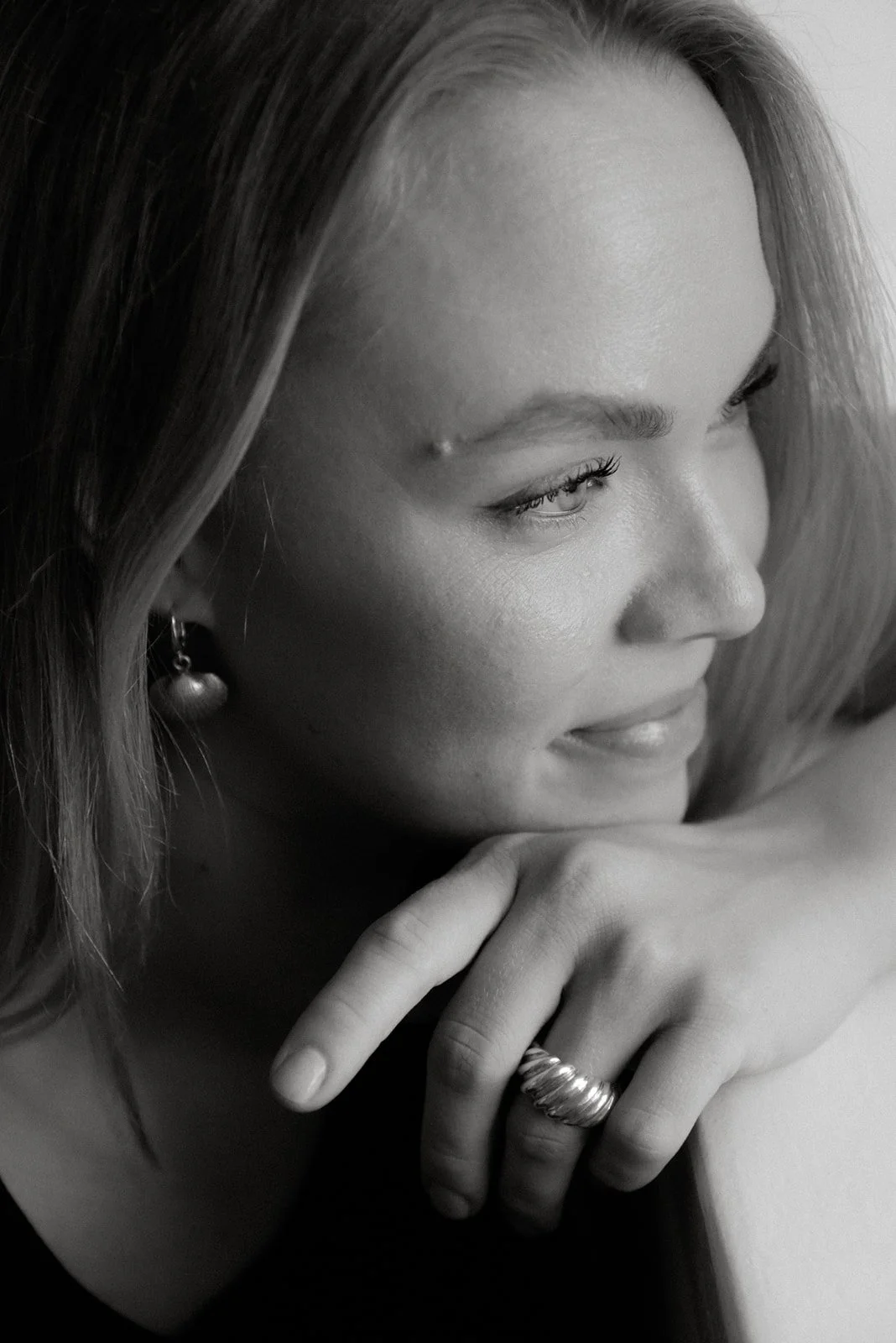 Yrityskuvaus studiolla. Yrittäjä itse suunnittelemansa sormus kädessään.