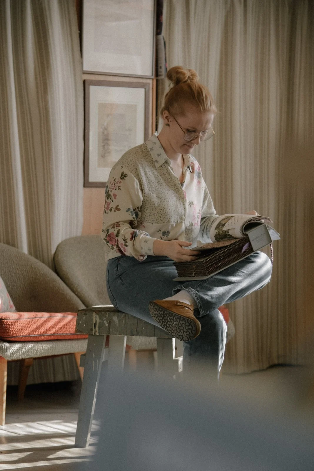 Verhoiluliike Eklundin brändikuvaus, yrittäjä Ida Eklund selaa kankaita.