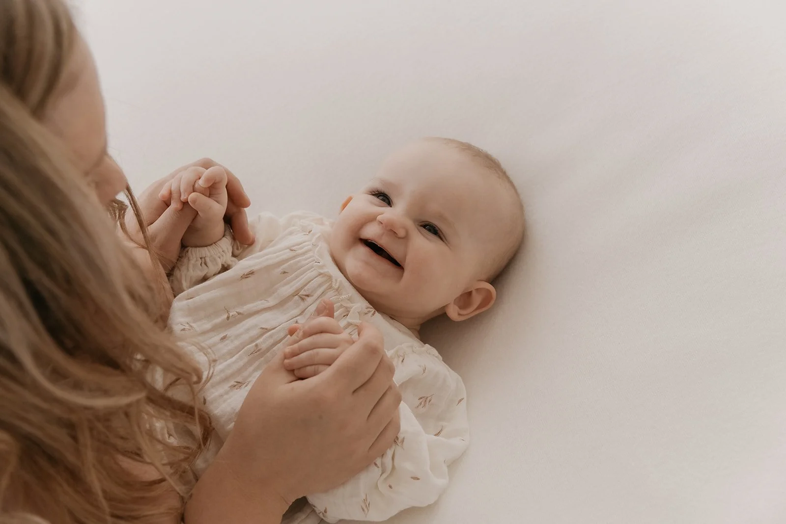 Heidi Väisänen kuvaa äitiä ja hymyilevää vauvaa studiollaan Keravalla.