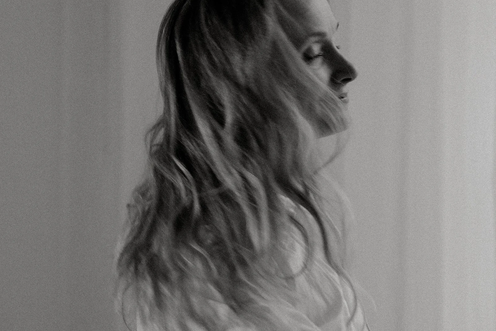 Vaumiin yrityskuvaus. Yrittäjä heilauttaa päätään mustavalkoisessa kuvassa.