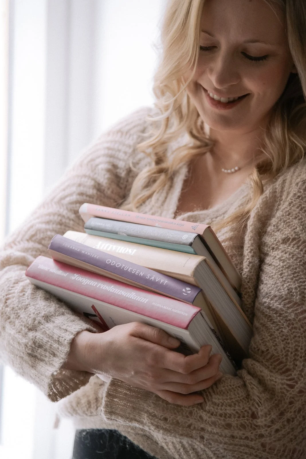 Sunsynnytys brändikuvaus. Yrittäjällä syli täynnä kirjoja.