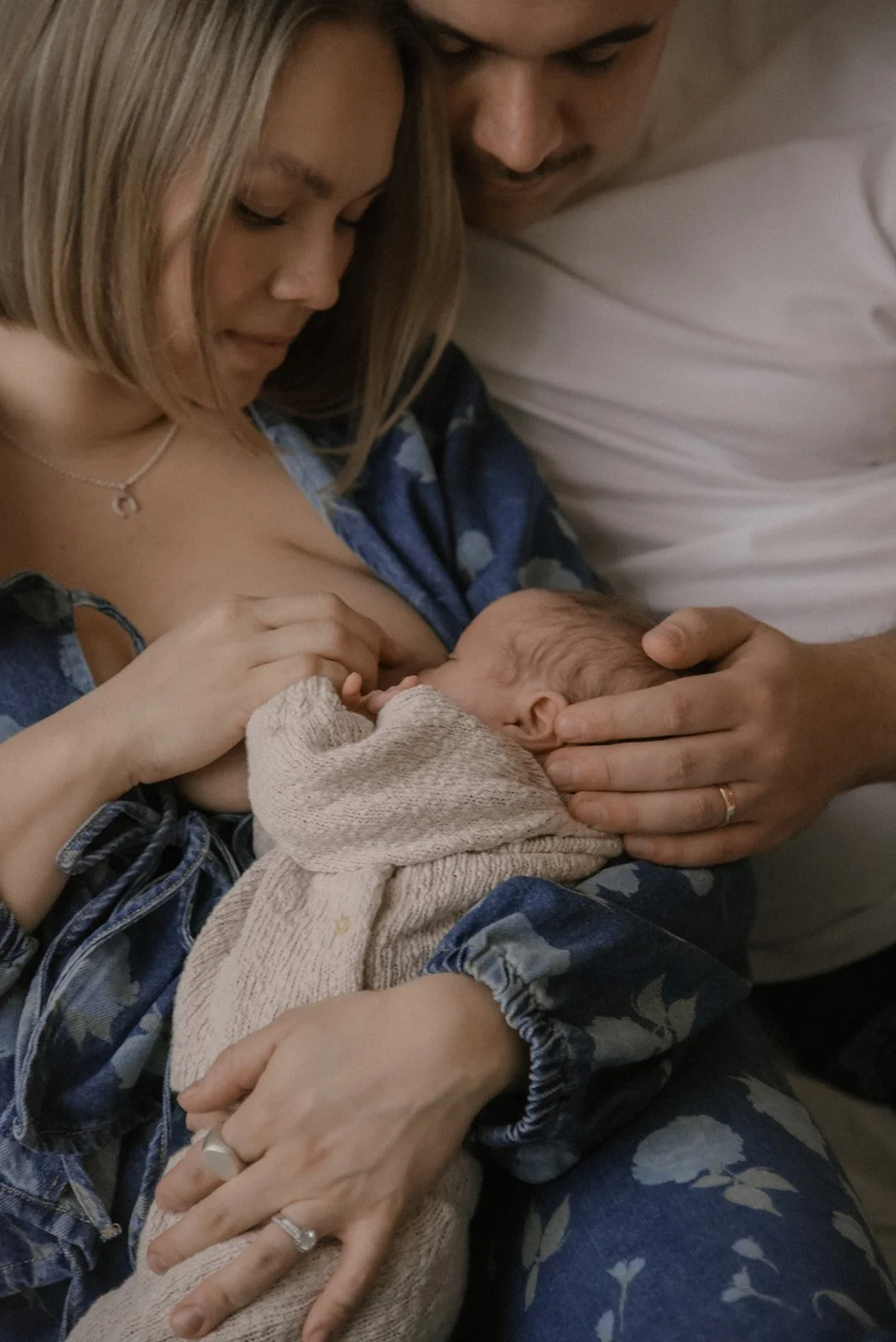 Vastasyntynyt vanhempien hellässä kosketuksessa. Kuvan on ottanut vauvakuvaaja Heidi Väisänen.