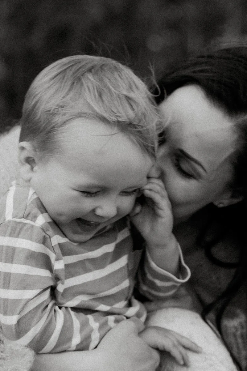 Perhekuvaus, äiti ja lapsi nauravaisina sylikkäin. Kuvannut valokuvaaja Heidi Väisänen.