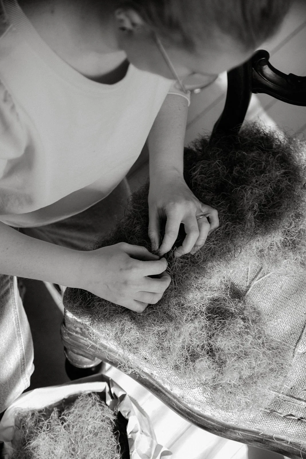 Verhoiluliike Eklundin yrityskuvaus. Mustavalkoisessa kuvassa yrittäjä työssään.