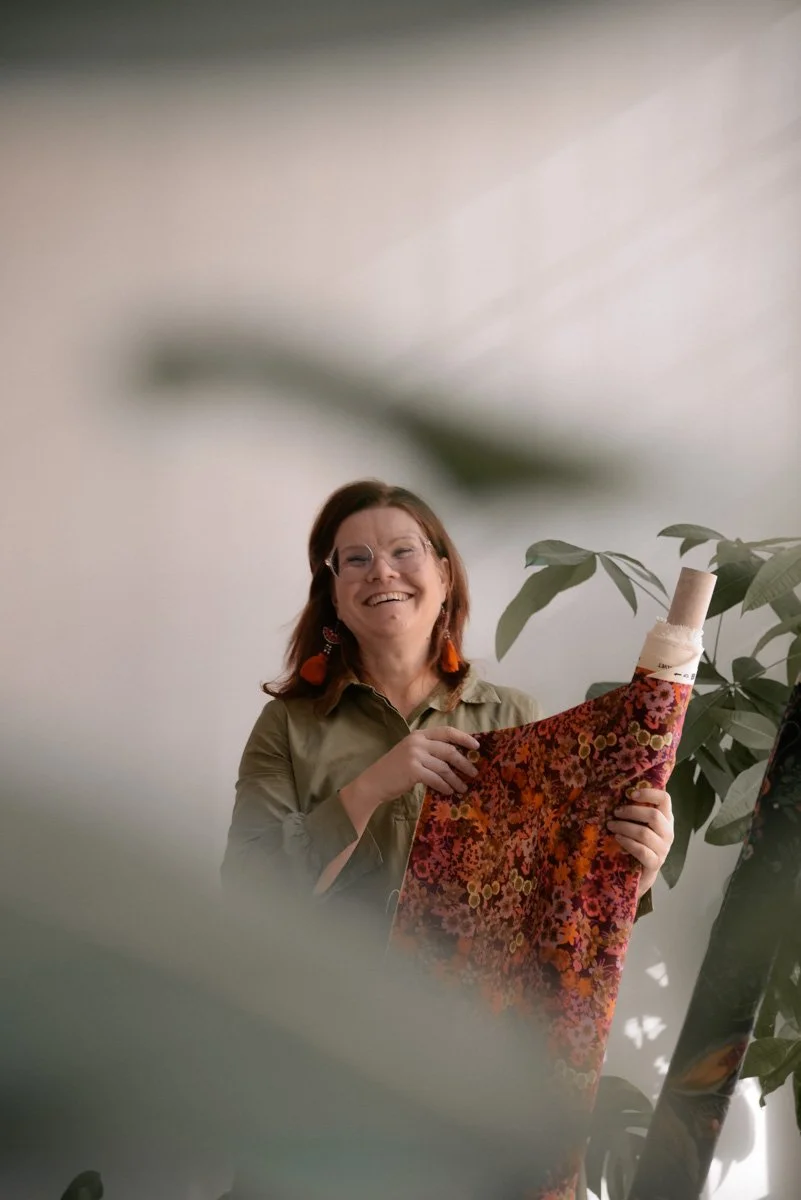 Verhoomoyrittäjä Virve työssään, pitelee käsissään kangasrullaa. Kuvannut henkilökuvaaja Heidi Väisänen.