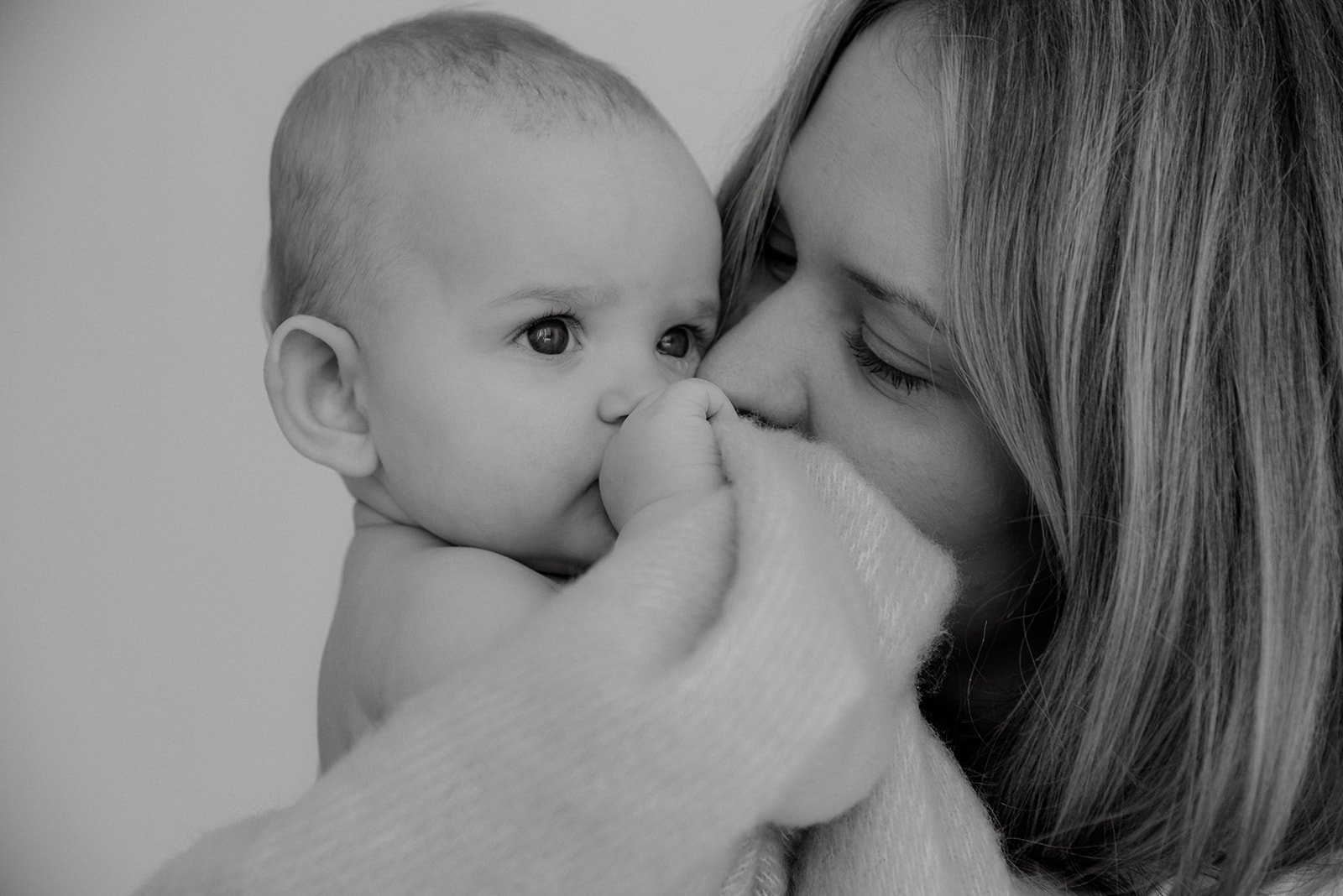 Äiti koskettaa lastaan rauhoittavasti. Mustavalkoinen äiti-lapsikuva, kuvannut Heidi Väisänen.