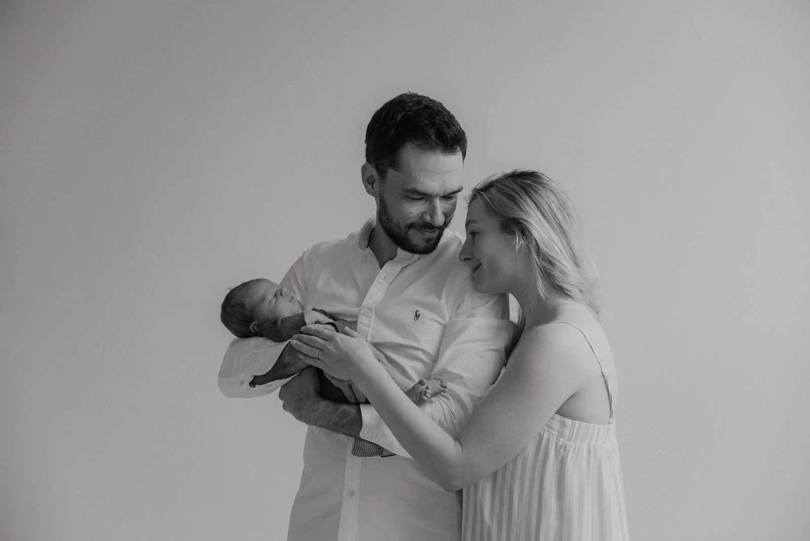 Vastasyntyneen kuvaus luonnonvaloa tulvivassa studiossa. Mukana vauva ja vanhemmat.