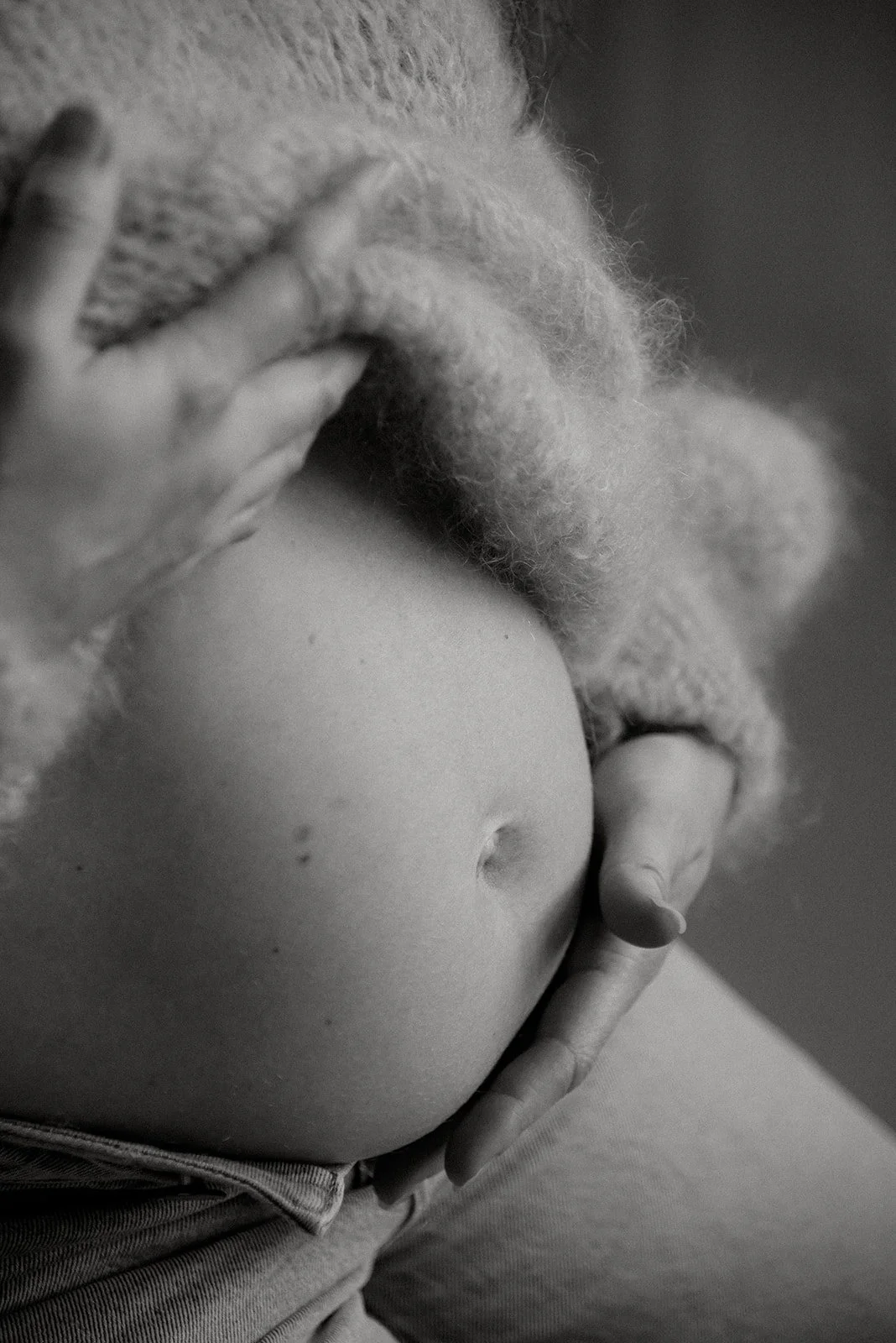 Nainen pitelee käsillään raskausvatsaa. Odotusajankuvaus studiossa.