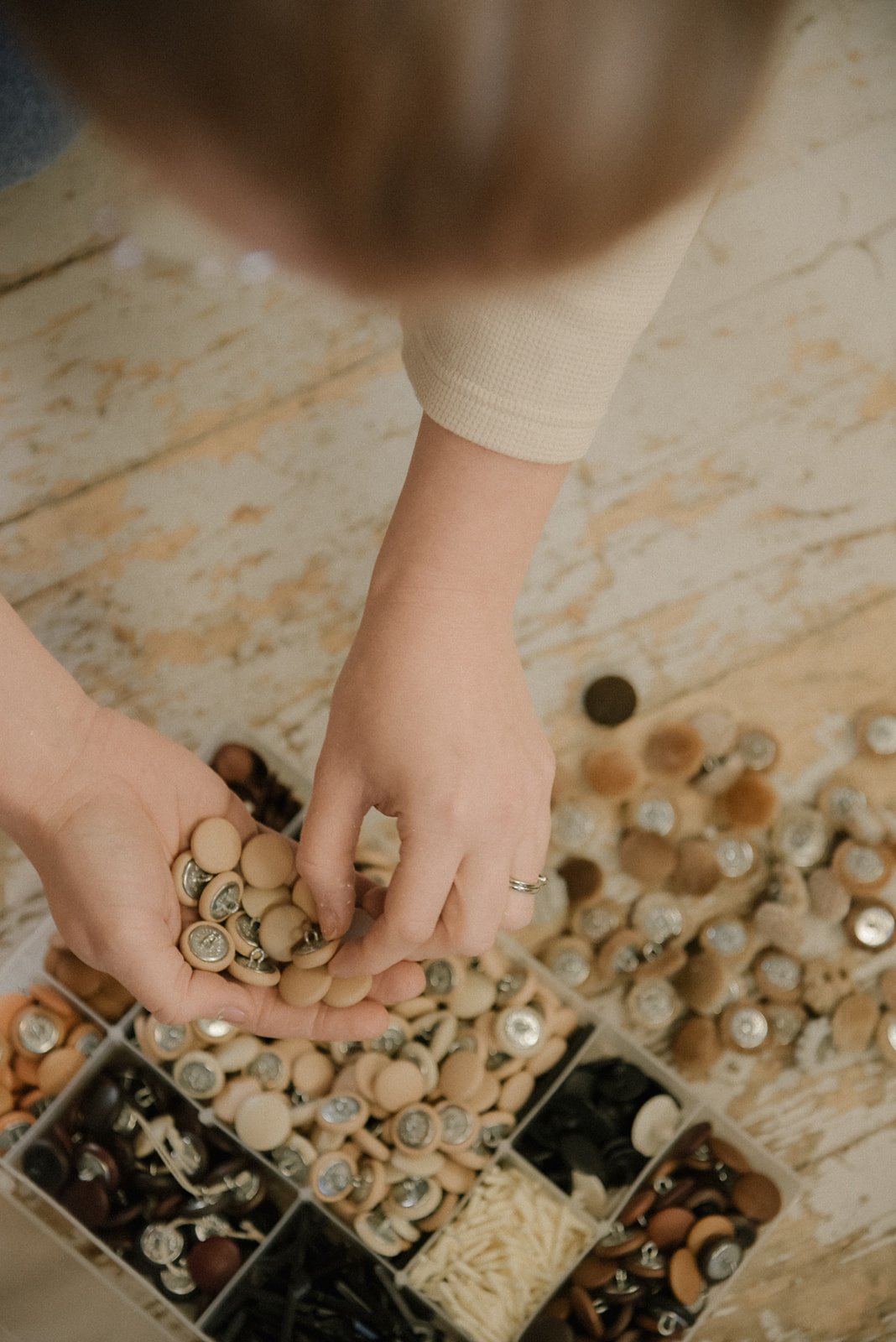 Verhoiluliike Eklundin yrityskuvaus, kuvassa yrittäjä lajittelee nappeja.