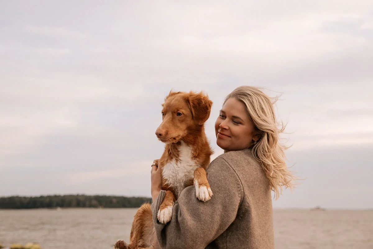 Odottava äiti ja koira kuvattavana luonnossa.