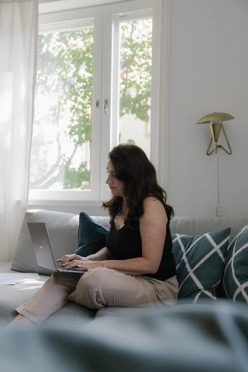 Neam Societyn yrityskuvaus, yrittäjä naputtelee tietokonetta rennosti sohvalla.