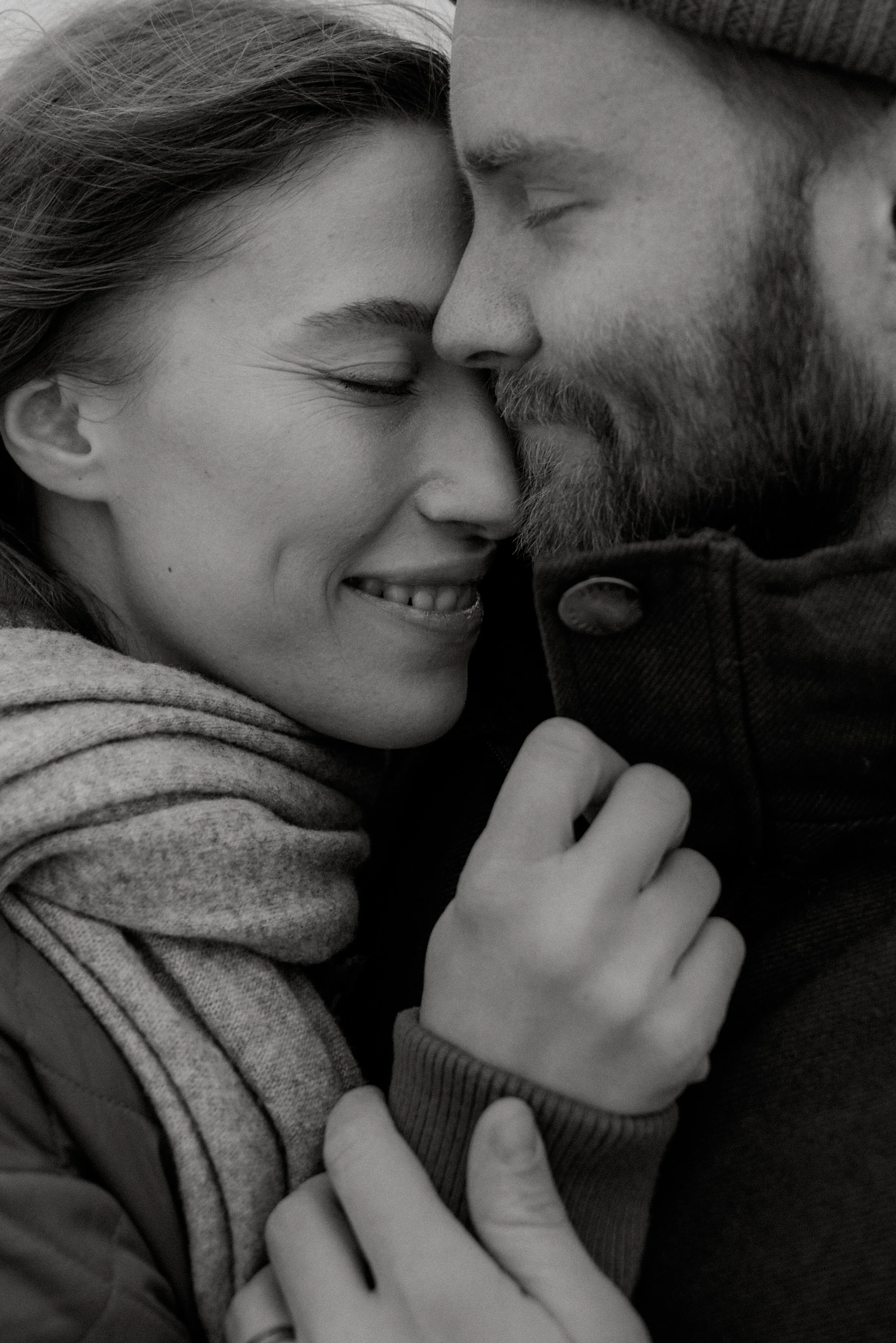 Mustavalkoinen lähikuva, jossa syleilevä pariskunta. Kihlakuvaus Espoo.