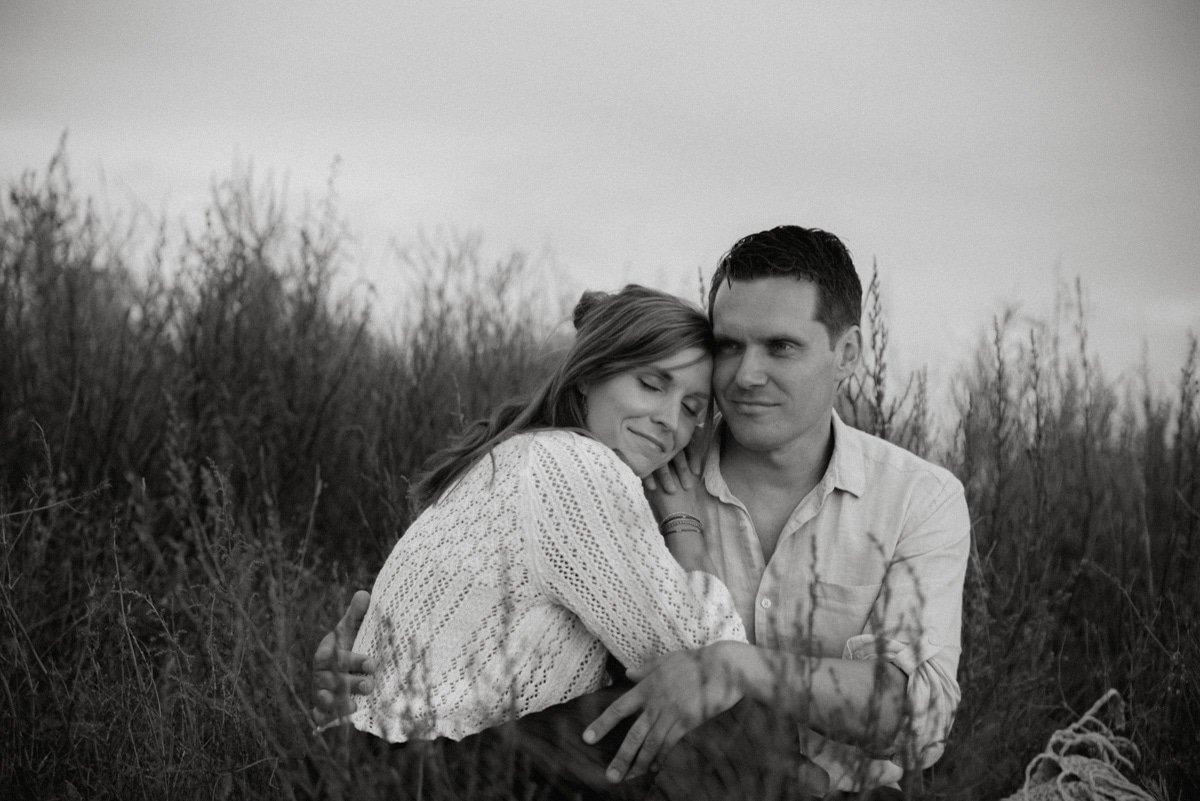 Perhekuvaus Helsinki, vanhemmat halaavat toisiaan keskellä niittyä.