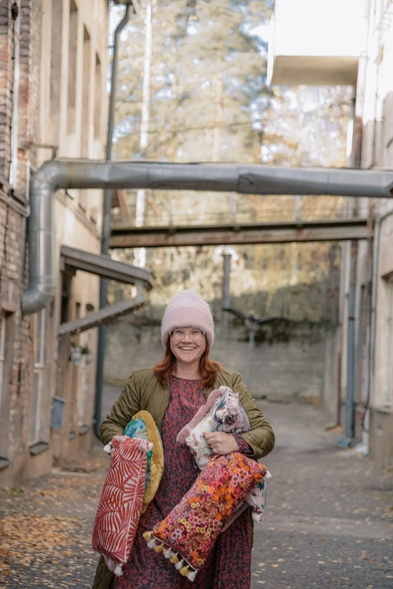 Verhoomo Vanhan Viehätys brändikuvaus, yrittäjä Virve Taljavirta pitelee käsissään värikkäitä tyynyjä.