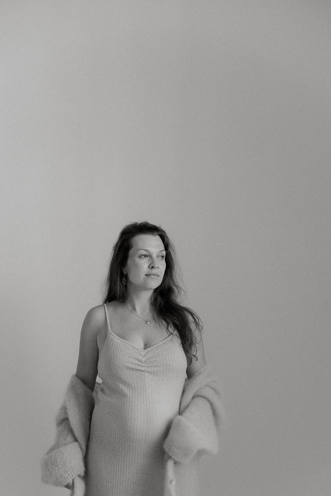 Mustavalkoinen odotusajan kuva raskaana olevasta naisesta. Kuvattu Heidi Väisäsen studiolla.